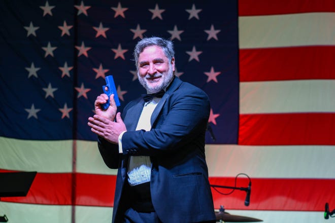 A participant in the Concealed Carry Fashion Show poses on stage.