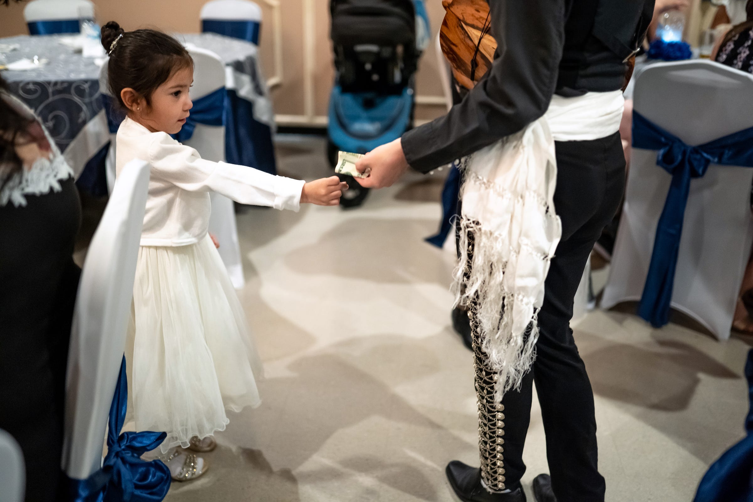 A young girl gives a tip to Mariachi Femenil Detroit director
Camilla Cantu of Detroit after they played at her table during a quincea–era in Dearborn Heights on Saturday, June 12, 2021.