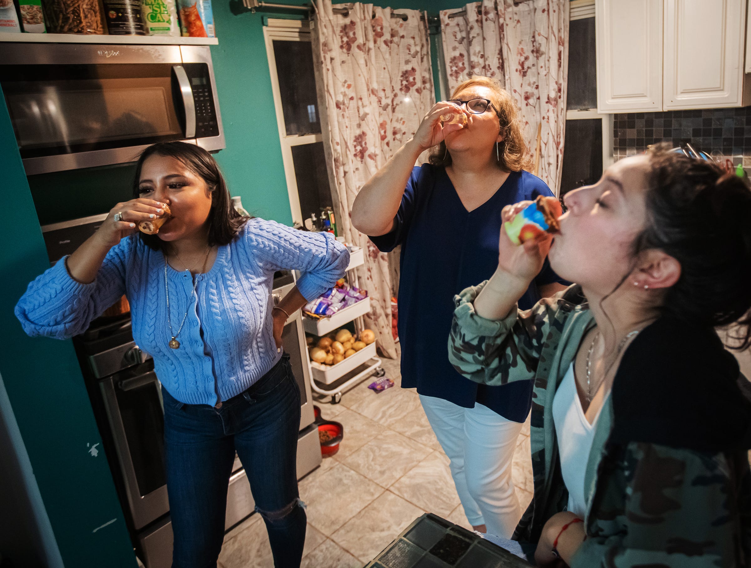 From right, Mariachi Femenil Detroit director Camilla Cantu of Detroit takes a shot with group members Alida Cazares of Detroit and Rita Ramirez of Lincoln Park after a rehearsal at Ramirez's home on Friday, October 1, 2021.