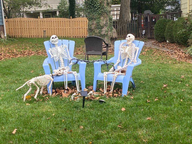 Two skeletons relax on Adirondack chairs at a home in South Orange.