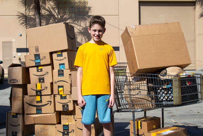 Zach Mandel, 13, of Boca Raton, stands with some of the food and toiletries he collected for Boca Helping Hands as part of his "COVID Care" project he undertook for his bar mitzvah.