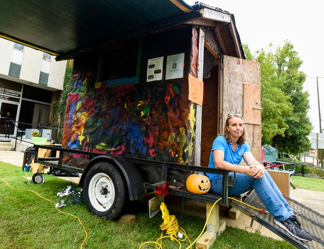The Rev. Lisa Pierce sits beside the small shack she lives in as a fundraiser for the Alabama Rural Ministry in Auburn, Alabama, on Tuesday, Oct. 12, 2021.