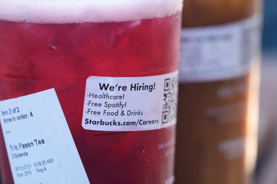 A sticker offering jobs adorns the side of a tea at a Starbucks Thursday, Oct. 7, 2021, in Sioux Falls, S.D.
