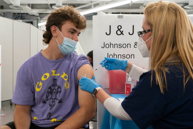 Bradley Sharp, of Saratoga, N.Y., gets the Johnson & Johnson vaccine from registered nurse Stephanie Wagner in New York.