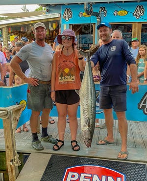Krista Cottom of Indiana pulled in this 27.6-pound king mackerel to get on the leaderboard of the Destin Fishing Rodeo on Wednesday. She was fishing with deckhand Jake Sargeant, left, and Capt. Judah Barbee, right, of the Stelluna.