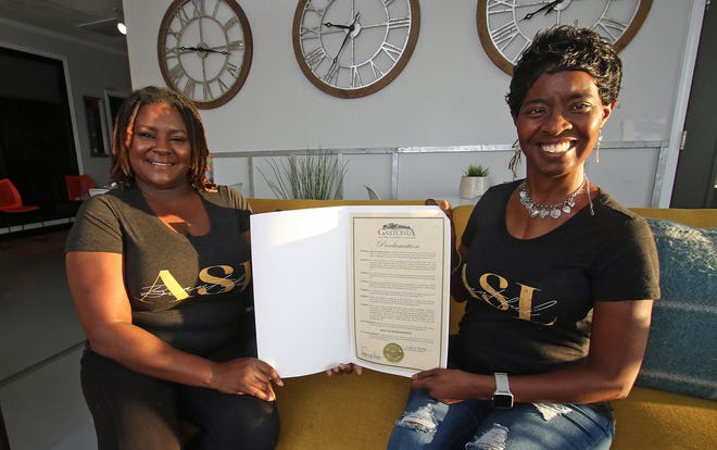 Starr Clinton and Dawn Johnson of  Nita's Silent Hands hold a proclamation for Deaf Awareness Month.
