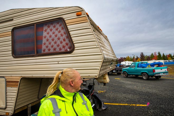 Katherine Nodine watches as a vehicle is towed past her camping spot in a new Safe Sleep site in Eugene. Displaced after the Holiday Farm Fire destroyed her home near Blue River, Nodine joined other residents in the new city-sanctioned spot while she makes payments on a piece of property near LaPine.