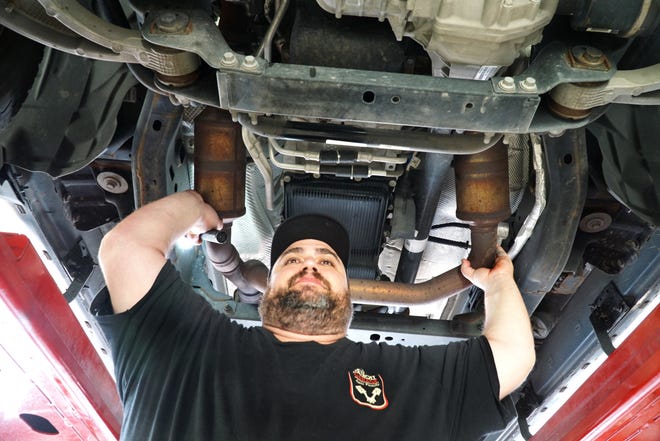 Plymouth Garage Manager Dan Mauti shows a pickup truck with two side-by-side catalytic converters. Mauti said that thieves using a powered hacksaw can remove two converters from autos within a minute or two and get about $150 for each converter due to their precious metal content.