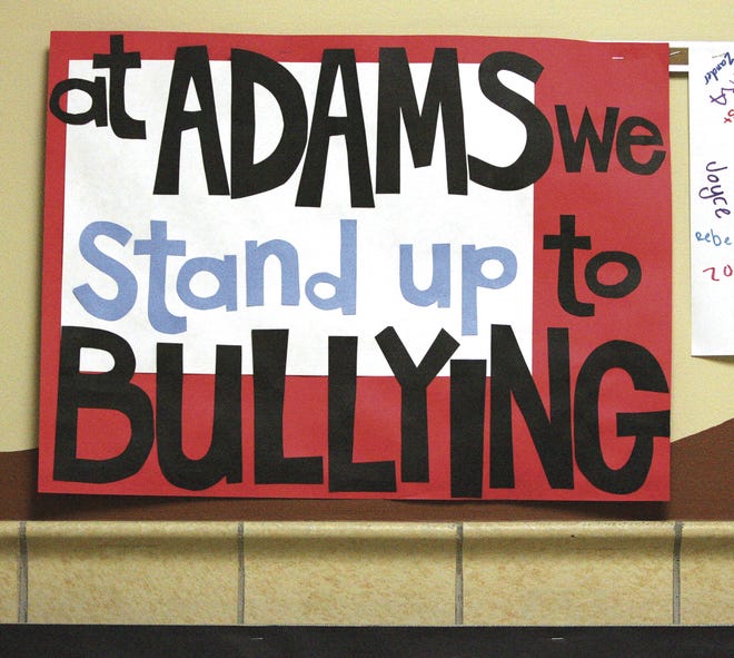In this Feb. 21, 2013 photo, this anti-bullying sign is prominently displayed in the hallway at Adams Elementary school in Janesville, Wisconsin, as part of a coordinated effort to reduce the negative behaviors in schools.