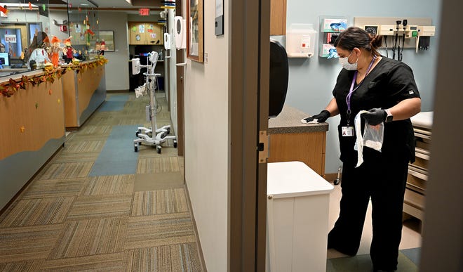Medical assistant Melissa Taranto cleans an exam room at the Edward M. Kennedy Community Health Center in Milford, Oct. 15, 2021. The center plans to increase its services by building a newer, bigger center directly across the street.