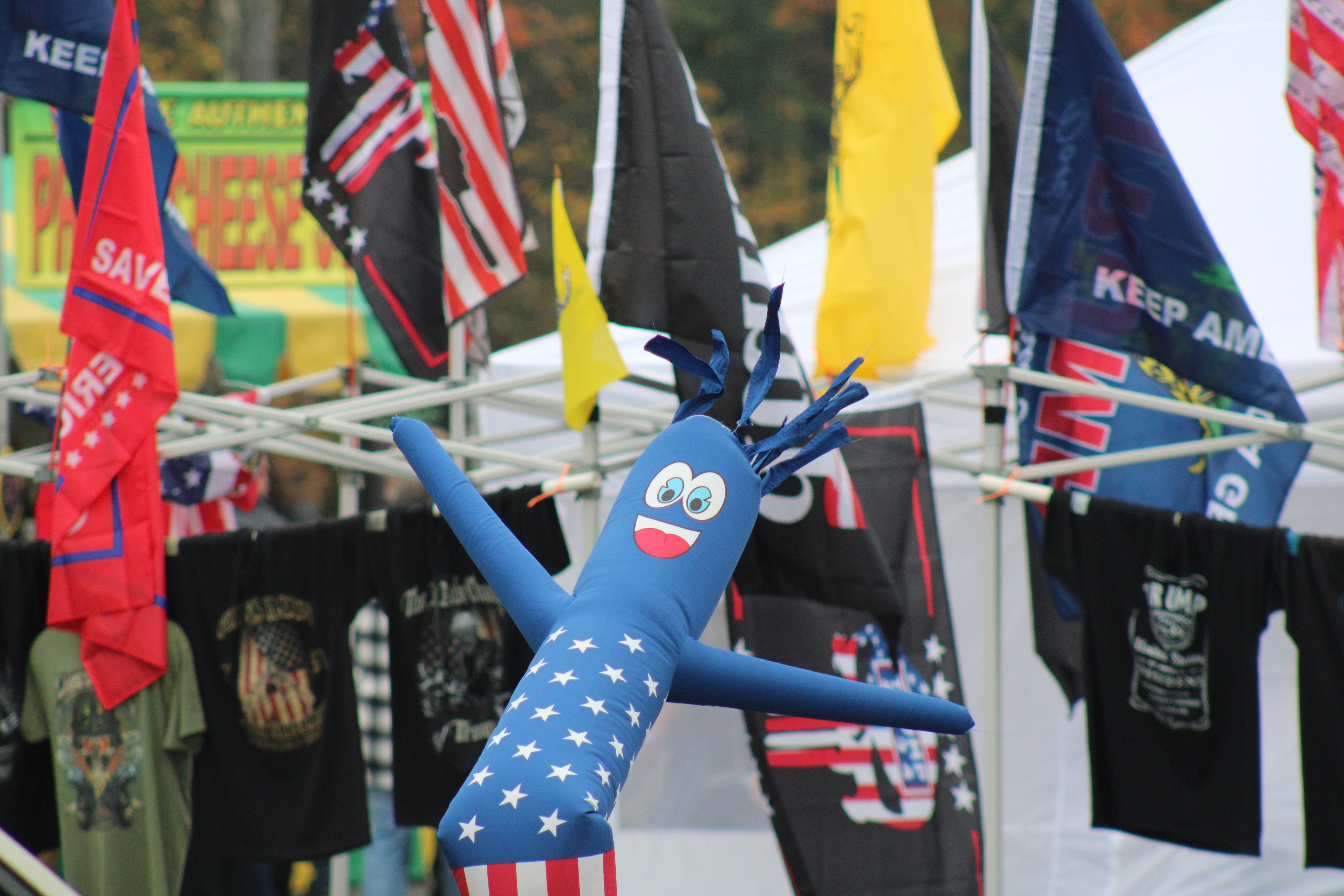 An inflatable American-themed man blows in the wind during the Rod of Iron Freedom Festival in Greeley, PA. Behind it, a vendor sold shirts and flags with conservative themes.