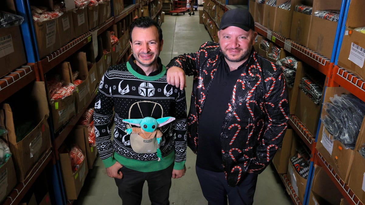 (L to R) Fred and Mark Hajjar, co-founders of UglyChristmasSweater.com inside their 42,000 square foot warehouse in Commerce Township, Michigan on Tuesday, October 12, 2021.  Their online retail store has a large supply of Christmas sweaters and other items stuck on freighters off the coast of California. 