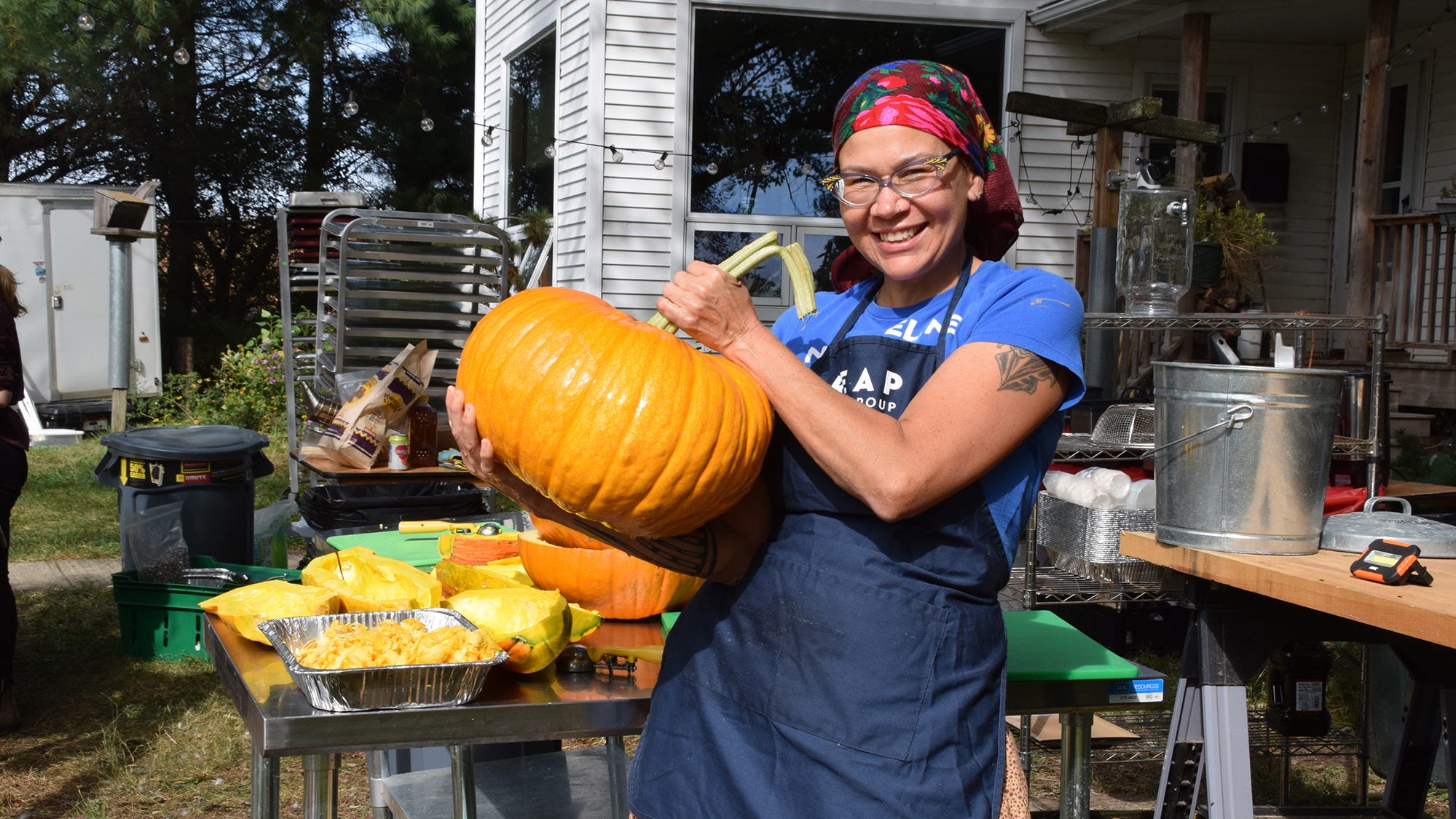 Shelley Buffalo, a food sovereignty consultant and member of the Meskwaki tribe, shows off a freshly picked pumpkin from the farm that was incorporated into a recent Harvest Dinner.