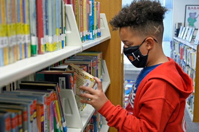 Jaymien Colon, Cottonwood Creek 6th grader, searches for a book to read from the school's library on Friday, Oct. 15, 2021.