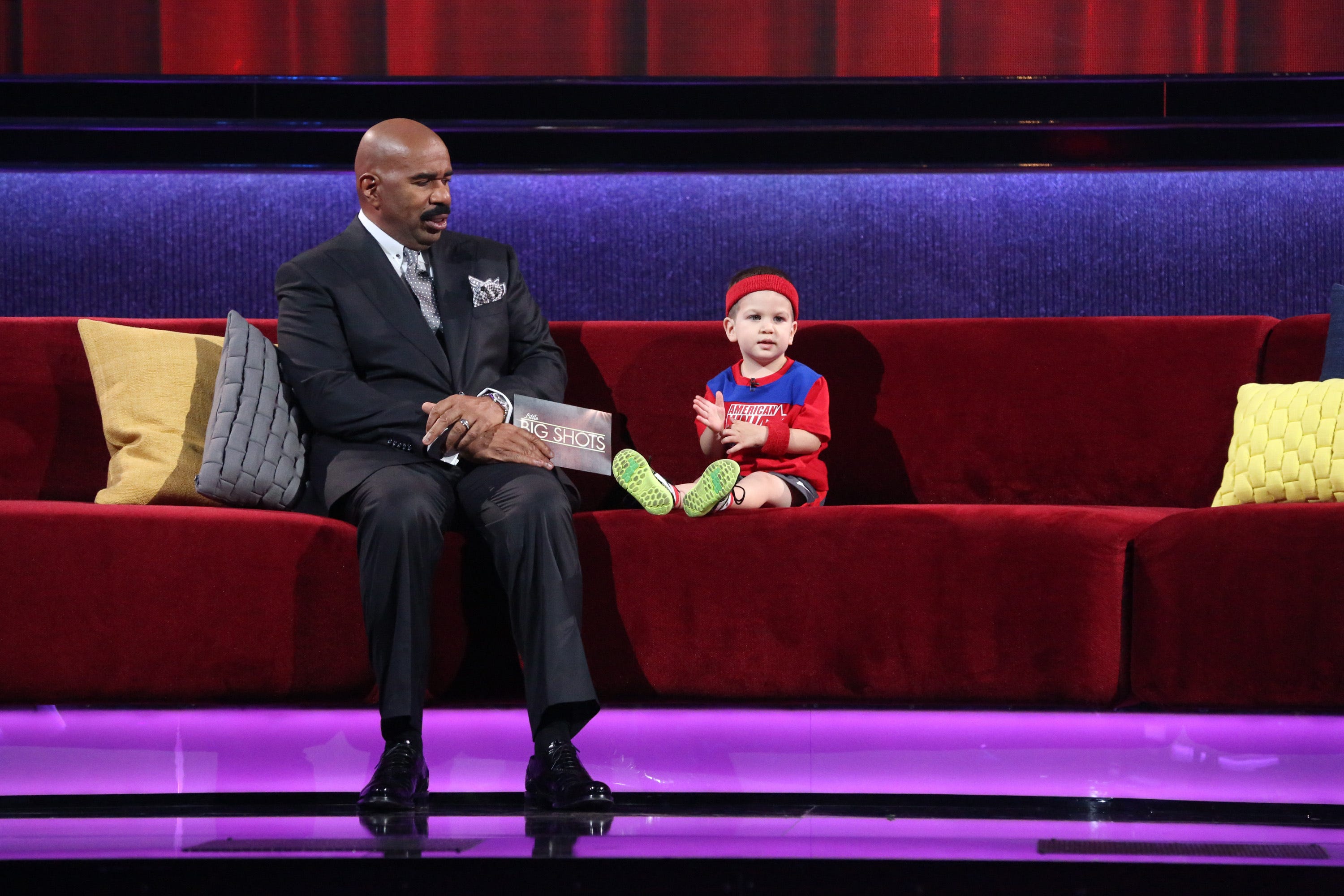 Steve Harvey, left, wears a classic suit while hosting NBC's "Little Big Shots."