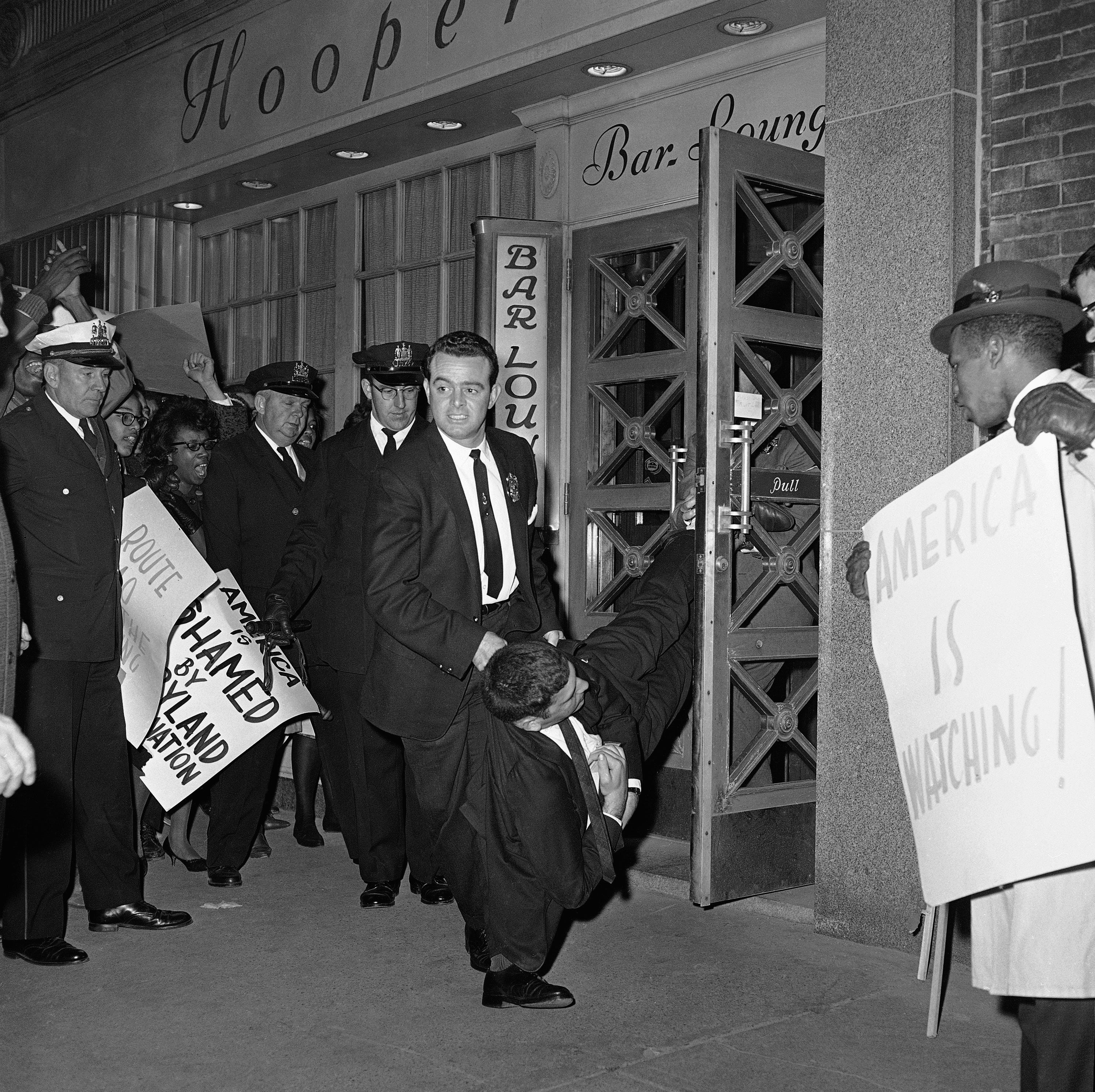A Baltimore detective carries a sit-in demonstrator from Hooper's Restaurant on Nov. 11, 1961. The unidentified demonstrator was one of nine arrested and charged with violating Maryland's trespass ordinance. Several hundred people -- some from Philadelphia, Washington and New York -- took part in the demonstrations against segregation throughout Baltimore and in several nearby counties. More people were arrested as the day wore on.