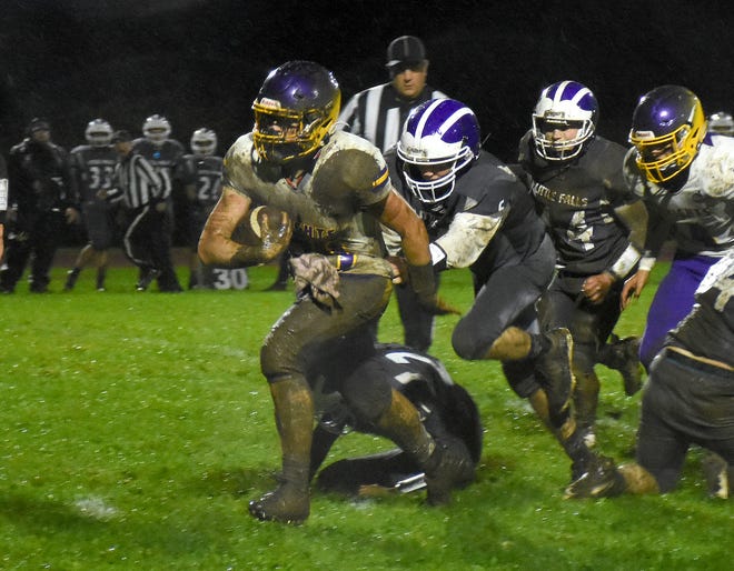 Little Falls Mountie Sam Phillips grabs Holland Patent ball-carrier Jonathan Zilinsky (left) from behind during the second quarter of Saturday's game played in Little Falls.