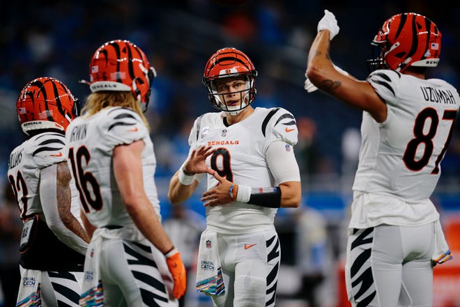 Cincinnati Bengals quarterback Joe Burrow (9) chats with teammates Trayveon Williams (32), Trenton Irwin (16) and C.J. Uzomah (87) before the start of the game against the Detroit Lions at Ford Field in Detroit on October 17, 2021.