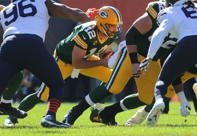 Packers quarterback Aaron Rodgers (12) plunges ahead to convert on fourth down against the Bears last season.