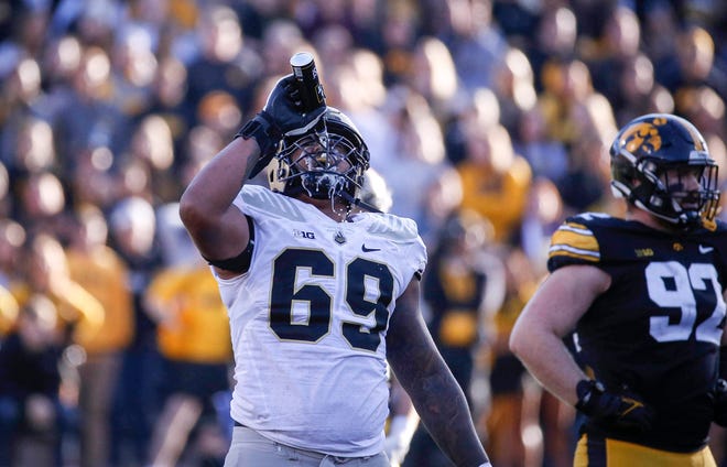 Purdue offensive lineman Greg Long pours a can of Bud Light over his face after a fan at Iowa's Kinnick Stadium tossed the beer onto the field in the third quarter.