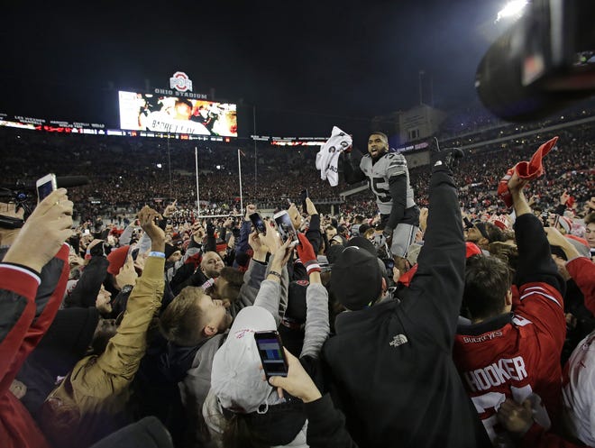 Linebacker Chris Worley celebrates with fans who rushed the field following Ohio State's 39-38 win over Penn State in 2017.