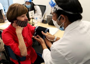 A patient gets her blood pressure checked as part of screenings during a Medicare health fair.