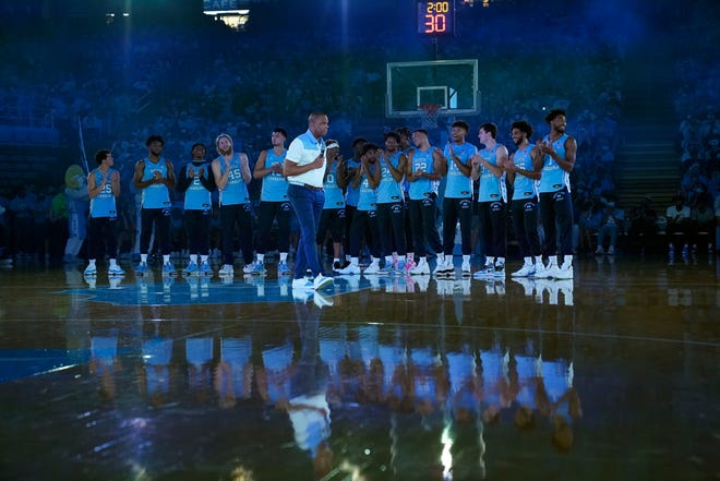 North Carolina coach Hubert Davis speaks with his team gathered at midcourt during the NCAA college basketball team's season opening event in Chapel Hill, N.C., Friday, Oct. 15, 2021.