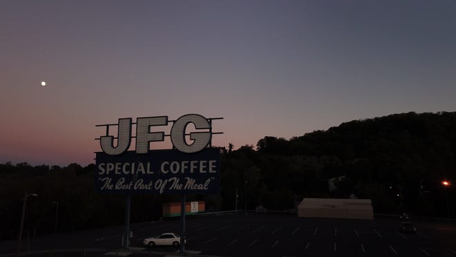 A drone photo by  Seth Proaps shows an aerial view of the sun setting behind the iconic JFG coffee sign in downtown Knoxville.