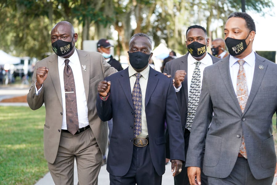 Attorney Ben Crump, left, and Marcus Arbery Sr., the father of Ahmaud Arbery, second from left, arrive at the Glynn County Courthouse as jury selection begins for the trial of the shooting death of Ahmaud Arbery on October 18, 2021 in Brunswick, Georgia. Three white men are accused of chasing down and murdering Arbery in southeastern Georgia last year.