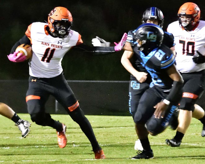 North Davidson tailback Xavion Hayes stiff-arms Oak Grove's Patrick Stephens. Hayes had three touchdowns in Friday's win over Asheboro. Stephens scored five touchdowns in Oak Grove's win over Ledford. [David Yemm for The Dispatch]