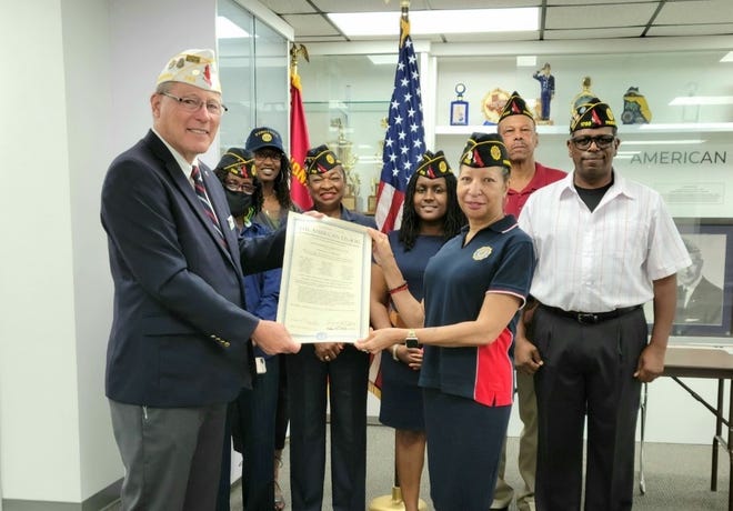 On the left, former Department Commander Bill Feasenmyer presents a permanent charter to American Legion Post 1703 Commander Mable Combo-Farris and members.