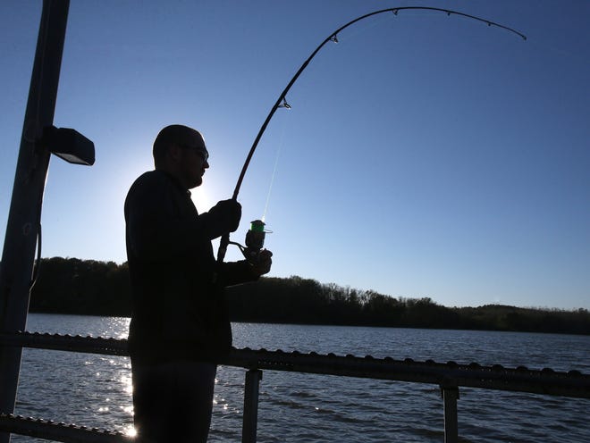 Christopher Kaylor tries to free his line after it got hung up on the bottom while fishing at Sippo Lake Park in Perry Township on Monday, Oct. 18, 2021.