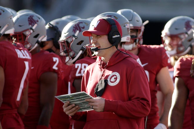 Washington State defensive coordinator and linebackers coach Jake Dickert, center, stands on the field during a break in play in the second half of an NCAA college football game, Saturday, Oct. 9, 2021, in Pullman, Wash. Dickert was named Washington State interim head coach, Monday, Oct. 18 after head coach Nick Rolovich was fired for refusing a state mandate that all employees get vaccinated against COVID-19. (AP Photo/Young Kwak)