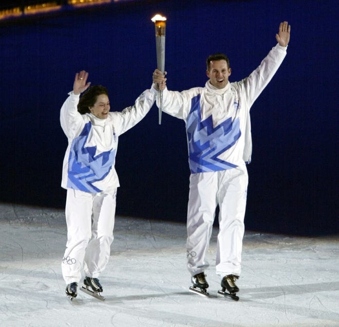 Bonnie Blair and Dan Jansen skate around Rice Ecckles Stadium with the Olympic flame during the opening ceremony of the 2002 Winter Olympic Games. P