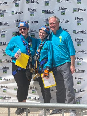 Hudson resident Melissa Jones, left, is pictured at Lifebanc's Over the Edge fundraising event in Cleveland on Sept. 3. Jones, along with co-worker Jenifer Novak, center, rappelled down the side of the 282 foot high Oswald Building in downtown Cleveland to raise money for Lifebanc. Joining them for the photo is Lifebanc CEO Gordon Bowen.