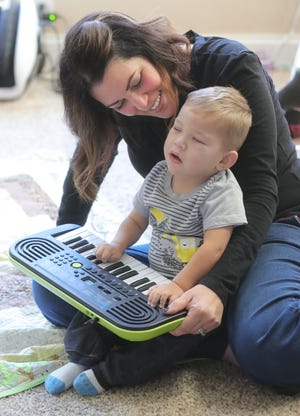 Carlla Detwiler plays music on the keyboard with her son David in the family's Massillon home.