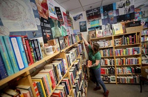 Owner Kate Larson stocks the shelves at her Ballast Book Co. in downtown Bremerton on Wednesday. Larson is among local retailers who say there's uncertainty about product shortages headed into the holiday season.
