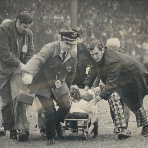 Lions receiver Chuck Hughes is rushed off the fiel