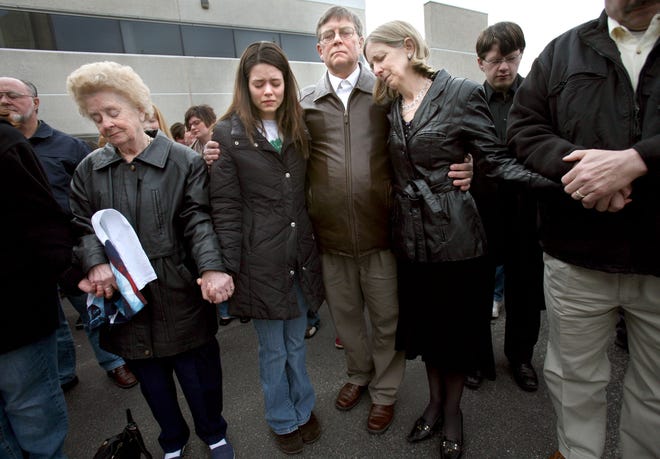 Kristen Nelson, center left, stands in prayer with the parents of her husband, Cpl. Richard "Ricky" Nelson, who was killed by a roadside bomb in Iraq this week during a remembrance ceremony for Ricky at Christian Life School in Kenosha, April 18, 2008. Ricky's parents, Lennie, center right, and Susan, far right, also attended the ceremony. Ricky graduated from the school in 2003 and Kristen, who was his high school sweetheart and wife of almost one year, graduated in 2006. Susan is the administrator of the school, and student Tim Britzman, 18, organized the event as a way to honor Ricky and help the students and staff at the school heal as well. Over 150 people attended the morning event that was held at the school flagpole.