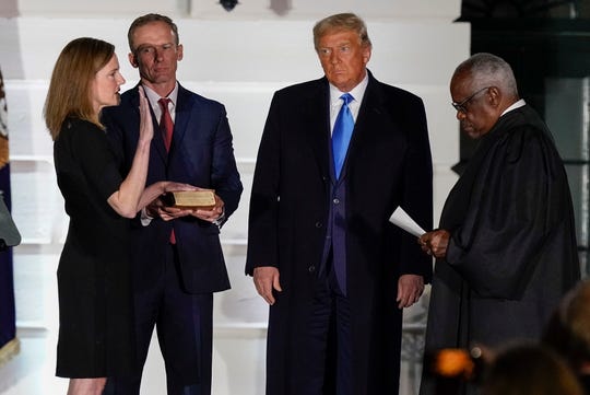 President Donald Trump watches as Supreme Court Justice Clarence Thomas administers the Constitutional Oath to Amy Coney Barrett at the White House in October 2020. Barrett's confirmation cemented a 6-3 conservative majority that's giving gun rights groups hope for an expansion of Second Amendment protections.