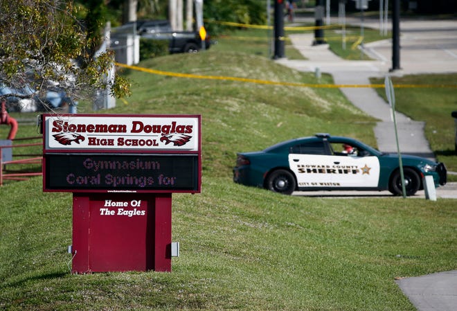 In this Feb. 15, 2018, file photo, law enforcement officers block off the entrance to Marjory Stoneman Douglas High School in Parkland, Fla., following a deadly shooting at the school.