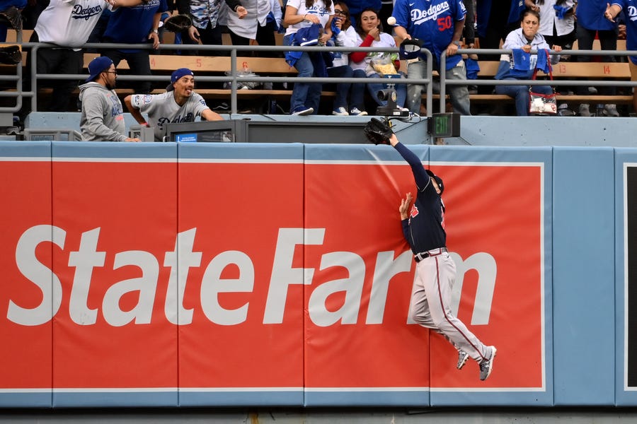 NLCS Game 4: Braves center fielder Adam Duvall makes a catch against the wall to rob Dodgers' Gavin Lux in the second inning.