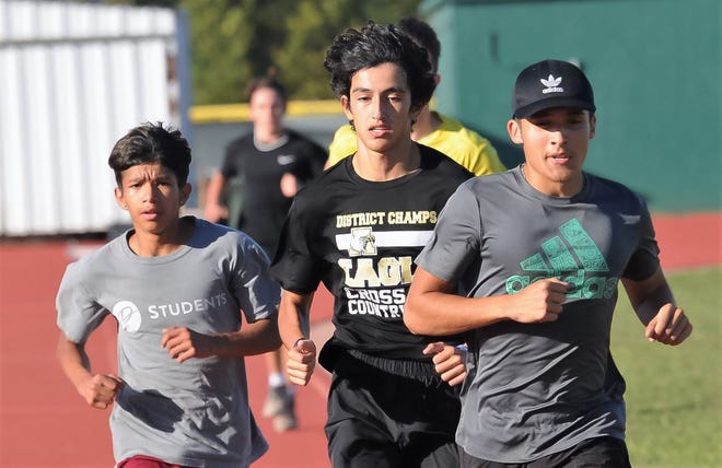 Abilene High's John Alcantar (left), Jordan Rodriguez (center) and Nicholas Gonzalez run during practice Tuesday at the Eagles' track.