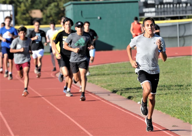Abilene High sophomore Andruw Villa, right, leads the Eagles during practice Tuesday at the school's track.