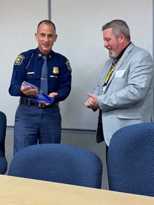 Michigan State Police Capt. Kevin Sweeny hands St. Clair County Office of Homeland Security and Emergency Management Deputy Director Mark White the 2020 Michigan Professional Emergency Manager of the Year award in a ceremony Thursday.