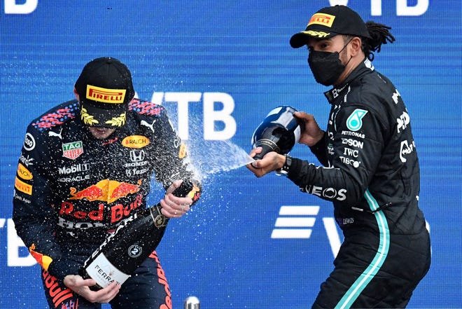 Lewis Hamilton, right, celebrates on the podium with Max Verstappen after the Formula 1 Grand Prix of Russia on September 26, 2021.