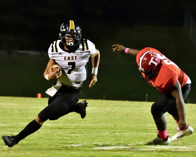 East Davidson quarterback  Brogan Hill is able to run around Thomasville's Jalen Harris to gain some yards Friday night at Thomasville. [David Yemm for The Dispatch