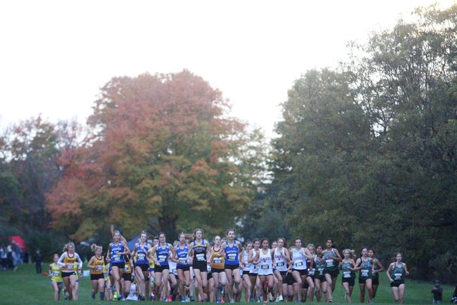 Runners take off at the start of the girls Division 1 race during a cross country sectional at Lincoln Park Golf Course in Milwaukee.