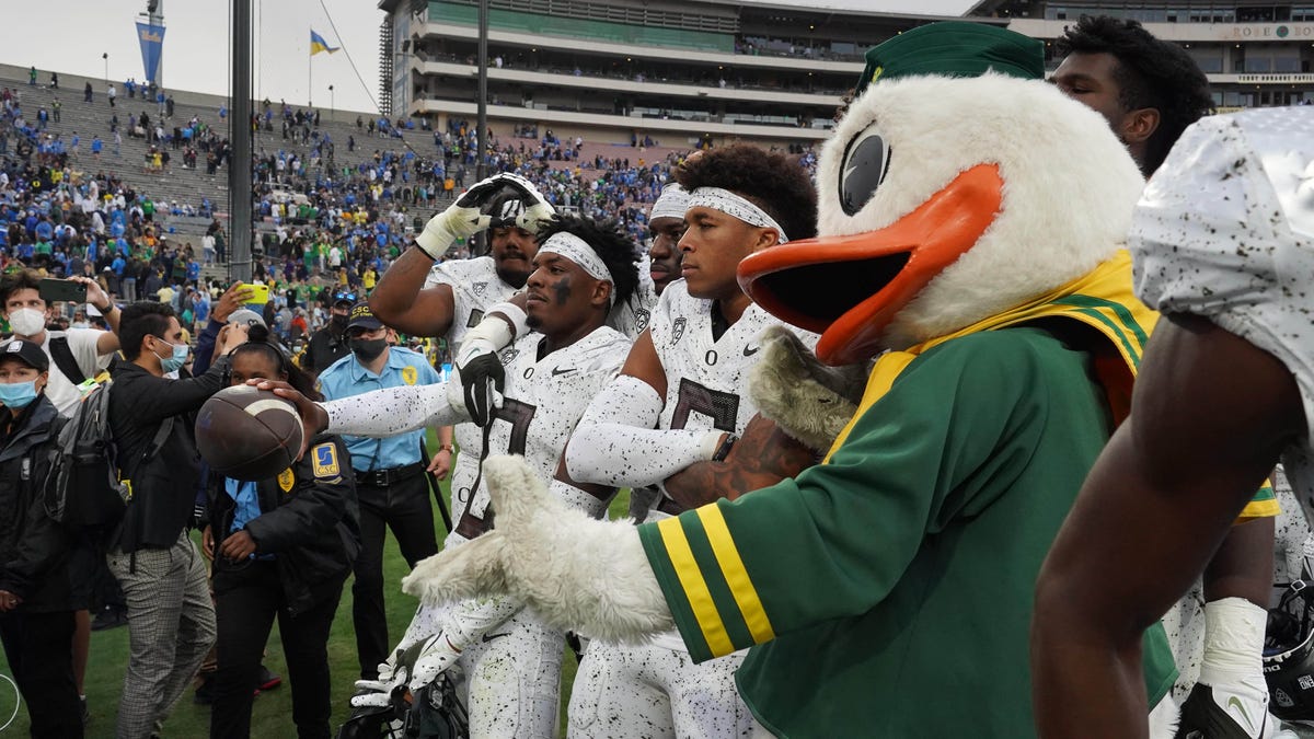 Oregon cornerback DJ James (0) poses with teammates and The Oregon Duck after the Ducks defeated UCLA.