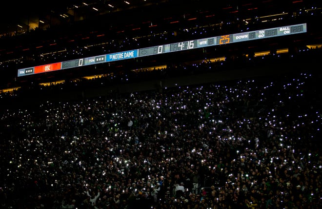 The stadium lights go dark as fans create a light show using their mobile phones before the Notre Dame-USC football game on Saturday, Oct. 23, 2021, at Notre Dame Stadium.